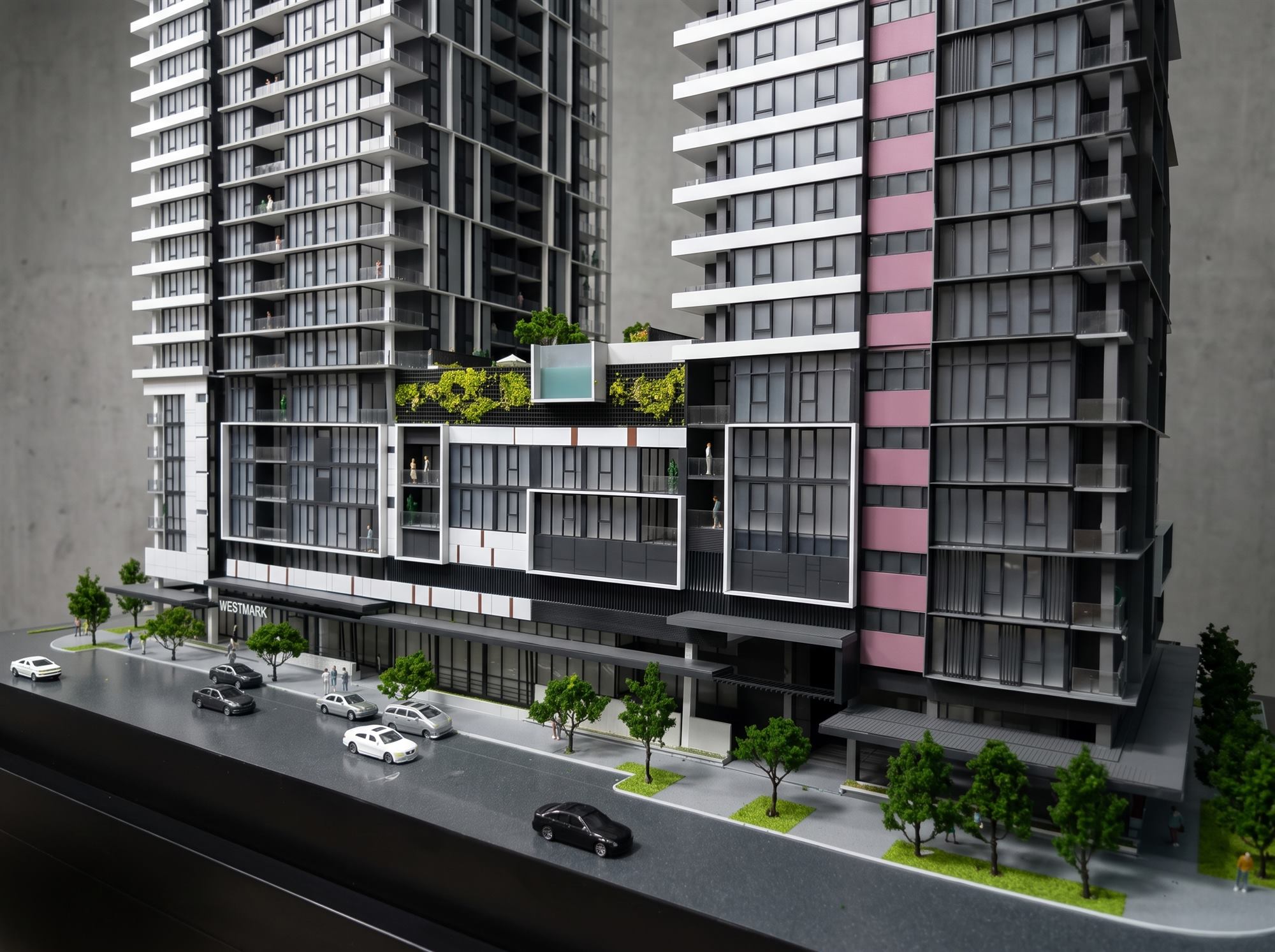 Detail of an AMOD scale model of two residential towers: balconies, a rooftop pool, planting, street trees, cars and figures, all built by hand