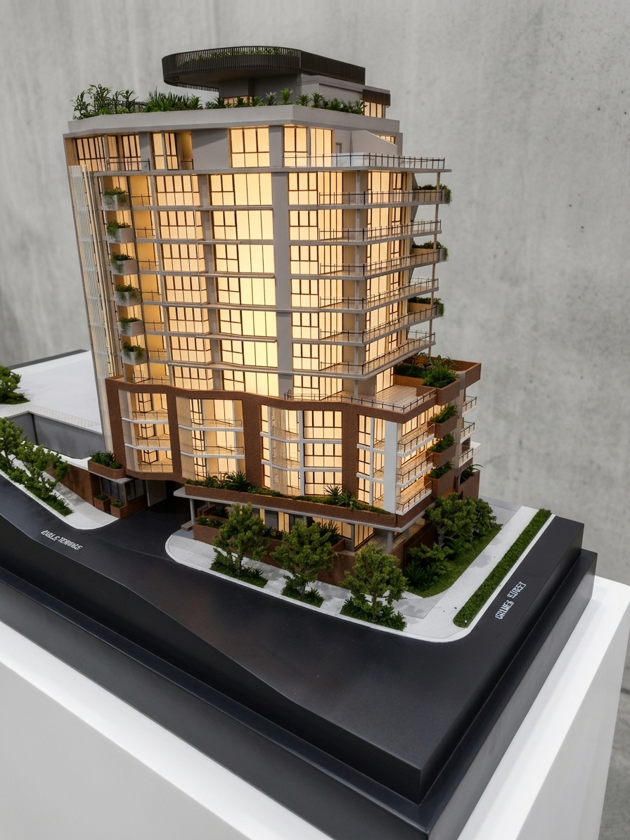 The Adler scale model lit from within, sunblade tower rising above brick podium with landscaped terraces on a black street base